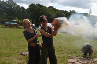 Rima makes fire with a bowdrill for the first time at Green Earth Awakening