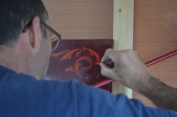 Ash paints steady-handed scrolls in the corners of our signboards